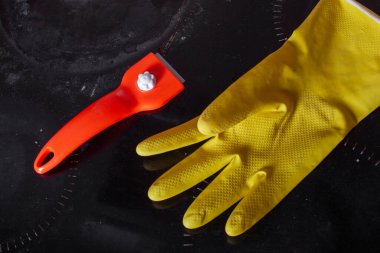 Cam seramikleri temizlemek için kazıyıcı ve cam seramik paneli temizlemek için lastik eldiven.