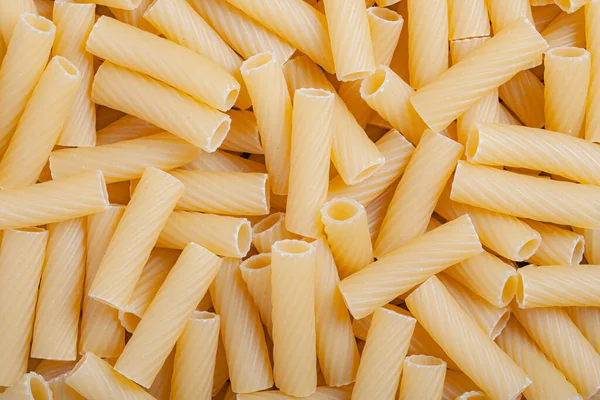 Raw italian durum wheat pasta tortiglioni background top view Royaltyfria Stockbilder