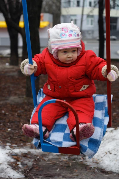 Little girl swinging at the playground — Stock Photo, Image
