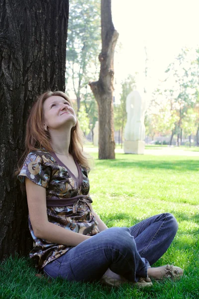 Flicka sitter under träd — Stockfoto