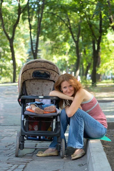 乳母車を持つ若い母親 — ストック写真