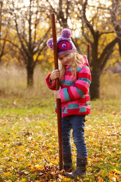 Fille avec râteau au jardin — Photo