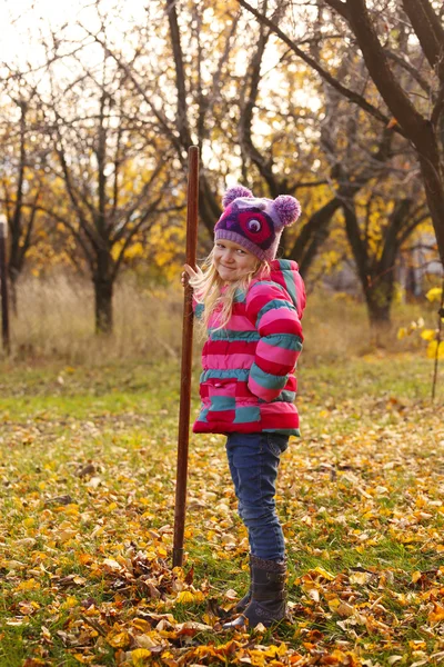 Ragazza con rastrello in giardino — Foto Stock