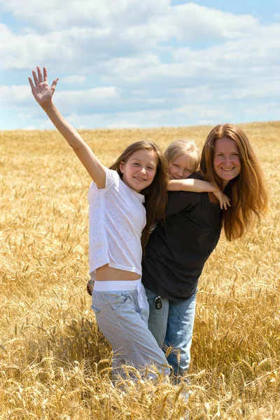 Moeder met dochters op tarweveld — Stockfoto