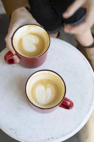 Zwei Rote Tassen Kaffee Auf Dem Tisch Und Die Beine — Stockfoto