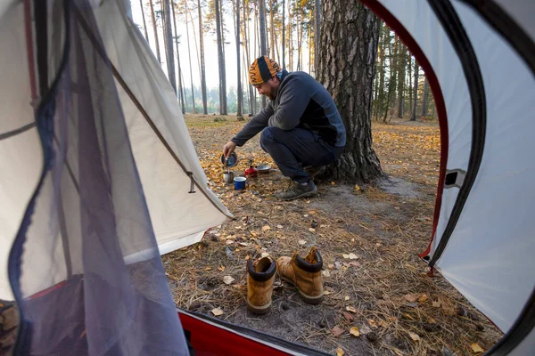 从一个正在做茶的徒步旅行者的帐篷和后面的森林里望去 — 图库照片