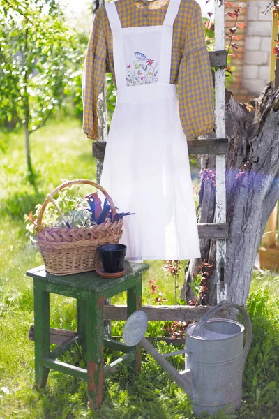 garden and flower transplant. apron with embroidery on the background of the garde