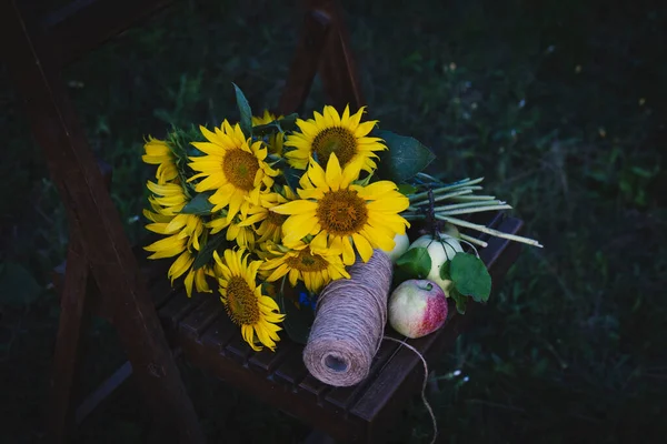bouquet of sunflowers lies on a vintage chair in the middle of the garde