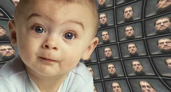 Un bebé frente a la cámara rodeado de pantallas distorsionadas de una O —  Fotos de Stock