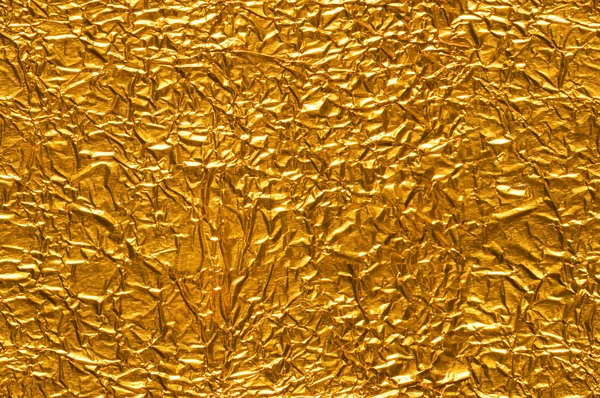 Geplisseerd goud folie achtergrond — Stockfoto