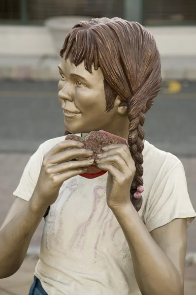 Sculpture of a girl eating called "Yum Yum" by J. Seward Johnson — Stock Photo, Image