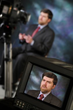 Monitor in studio showing man talking to video camera clipart