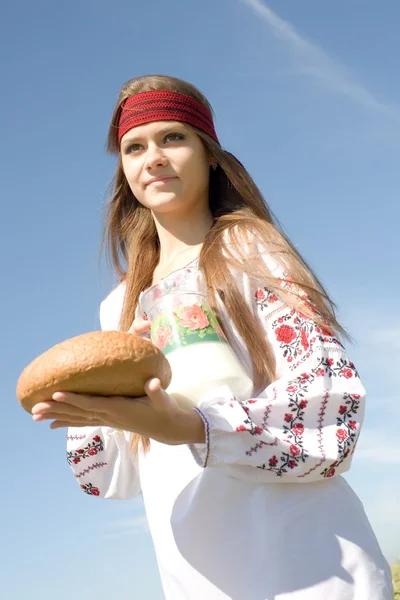 Menina bonita no campo com pão de centeio e leite — Fotografia de Stock