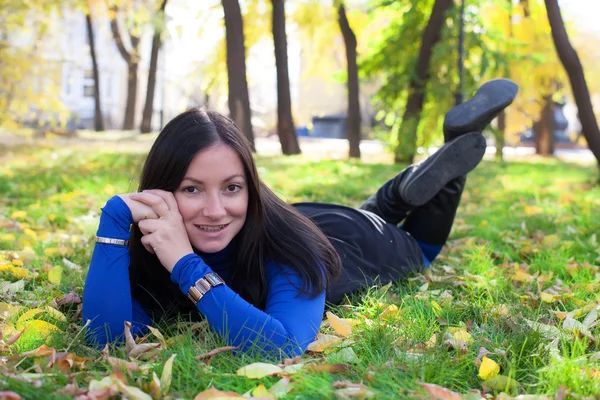 Flicka liggande på gräset i parken — Stockfoto