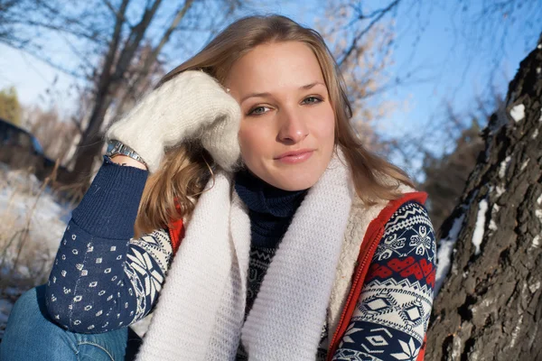 Chica en el bosque de invierno se sienta debajo de un abedul — Foto de Stock