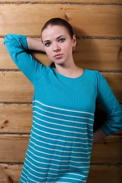 Young girl with a wooden wall — Stock Photo, Image