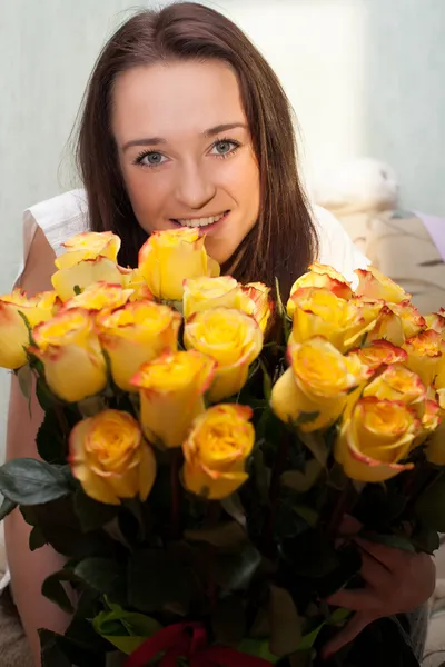 Menina alegre com um buquê de rosas amarelas — Fotografia de Stock