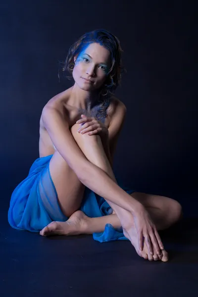 Ragazza nuda in un panno blu. ritratto dello studio — Foto Stock