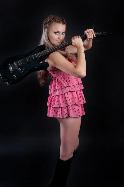 एक अंधेरे पृष्ठभूमि पर गिटार के साथ लड़की — स्टॉक फ़ोटो, इमेज