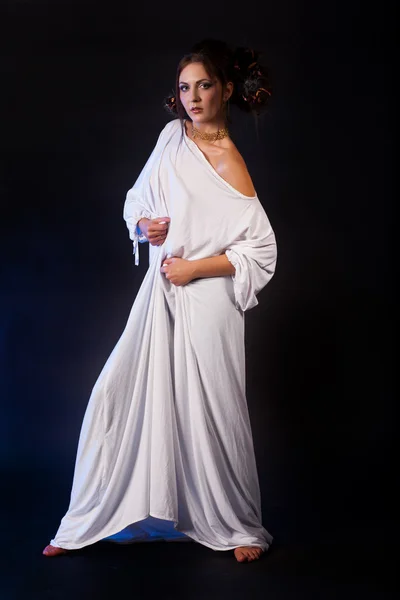 Beautiful young girl in a white dress on a dark background — Stock Photo, Image