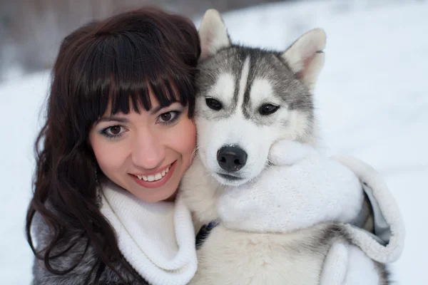 Brunett med hund i vinter skog — Stockfoto