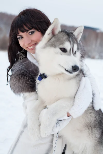 Брюнетка с собакой в зимнем лесу — стоковое фото