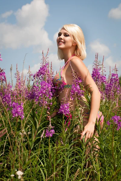 Belle jeune femme blonde parmi les fleurs sauvages — Photo