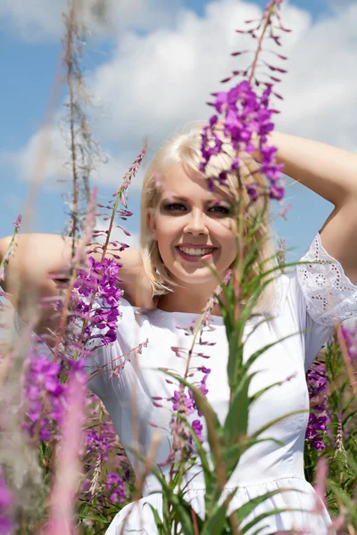 Giovane bella ragazza tra i fiori selvatici — Foto Stock
