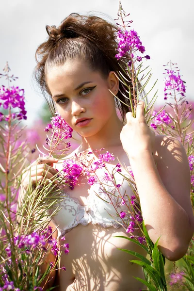 Beautiful young girl among the wildflowers — Stock Photo, Image