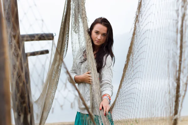 Girl in the rain on the beach in the fishing nets — Stock Photo, Image