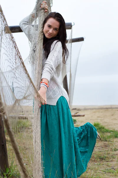 Girl in the rain on the beach in the fishing nets — Stock Photo, Image