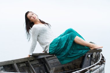 bir kıç tekne üzerinde oturan kız