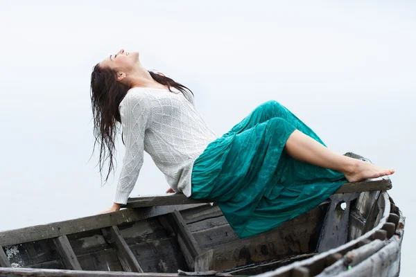 Chica sentada en una popa de un barco — Foto de Stock