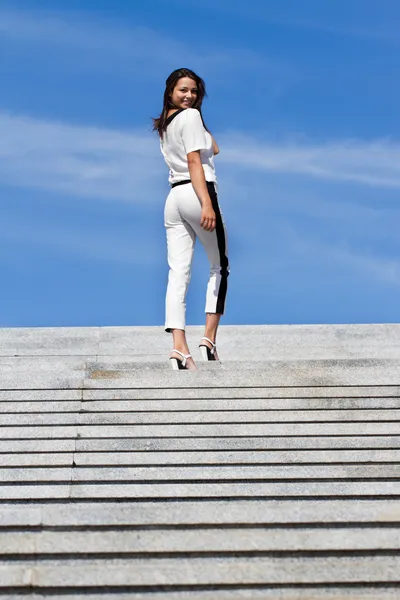 Girl goes up the stairs rising to the sky — Stock Photo, Image
