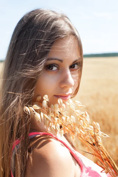 Joven hermosa chica en un campo maduro de avena — Foto de Stock