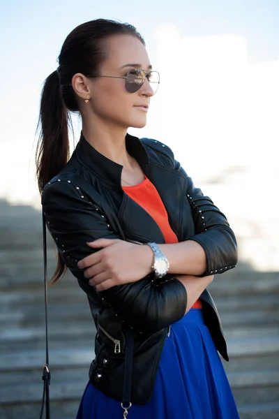 Lány a bőr kabát napszemüveg a kezében — Stock Fotó