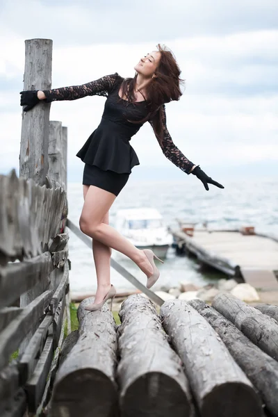 Girl in high heels standing on logs — Stock Photo, Image
