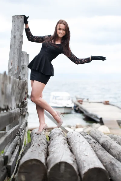 Girl in high heels standing on logs — Stock Photo, Image