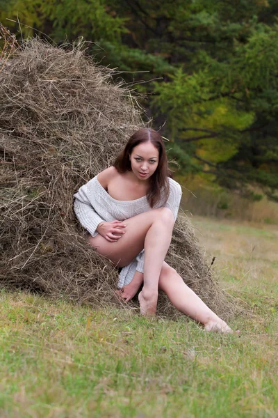 Ung flicka i skogen nära en höstack — Stockfoto