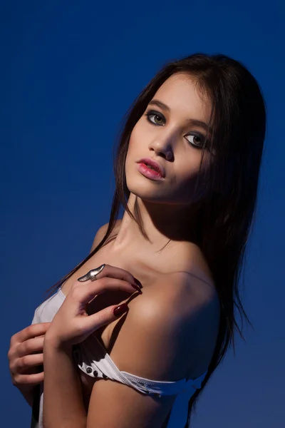 Retrato de estúdio de uma jovem sobre um fundo azul — Fotografia de Stock