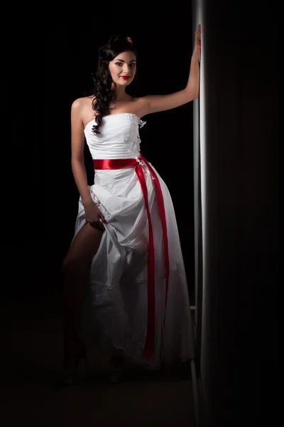 Bride in a white dress with a red ribbon — Stock Photo, Image