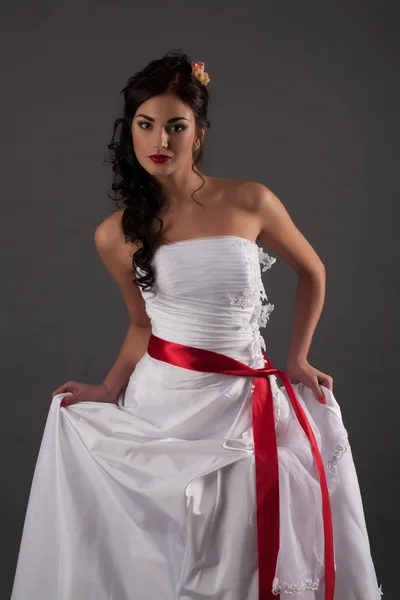Novia en vestido blanco con cinta roja — Foto de Stock