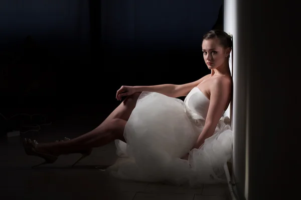 Bruden sitter på golvet, lutad mot väggen — Stockfoto