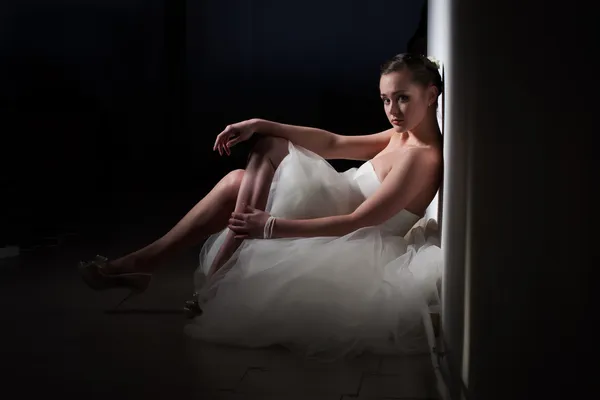 Bruid zittend op de vloer, leunend tegen de muur — Stockfoto