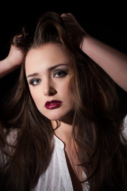 siyah bir arka plan üzerinde beyaz bir gömlek bir kızın portresi