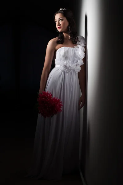 Bride in a white dress in a beam of light — Stock Photo, Image
