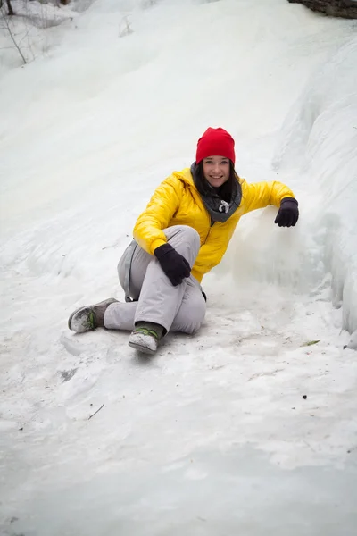 Meisje, zittend op het ijs tussen de rotsen — Stockfoto