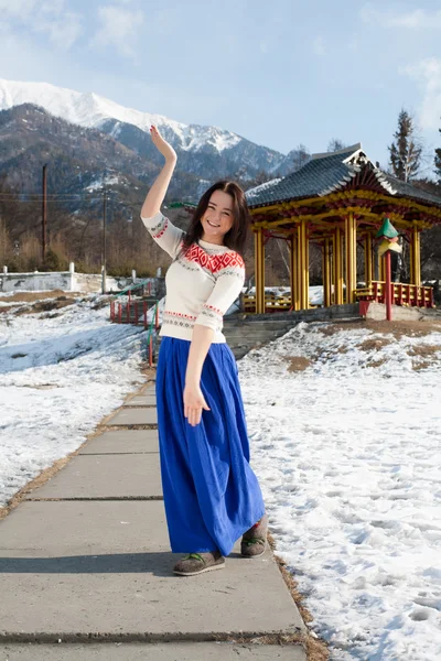 Girl in long skirt dancing on the background of mountains — Stock Photo, Image