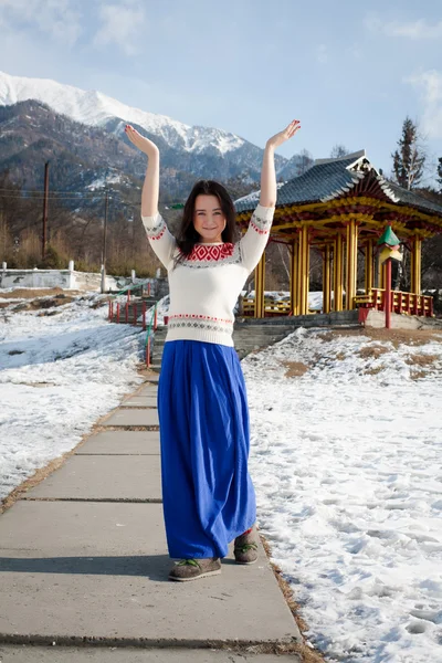 Girl in long skirt dancing on the background of mountains — Stock Photo, Image