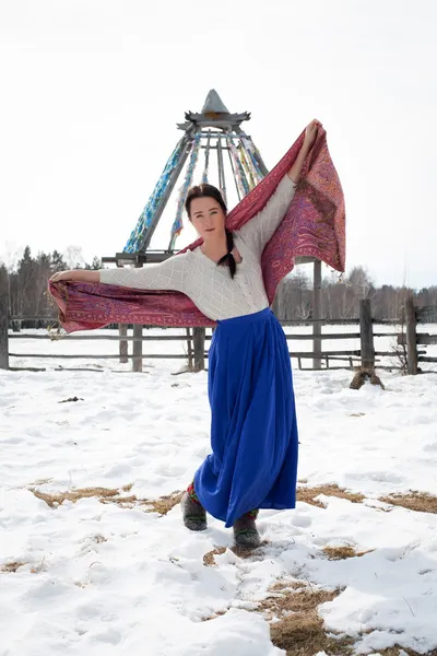 Ung pige i en lang nederdel på baggrund af en vinterskov - Stock-foto